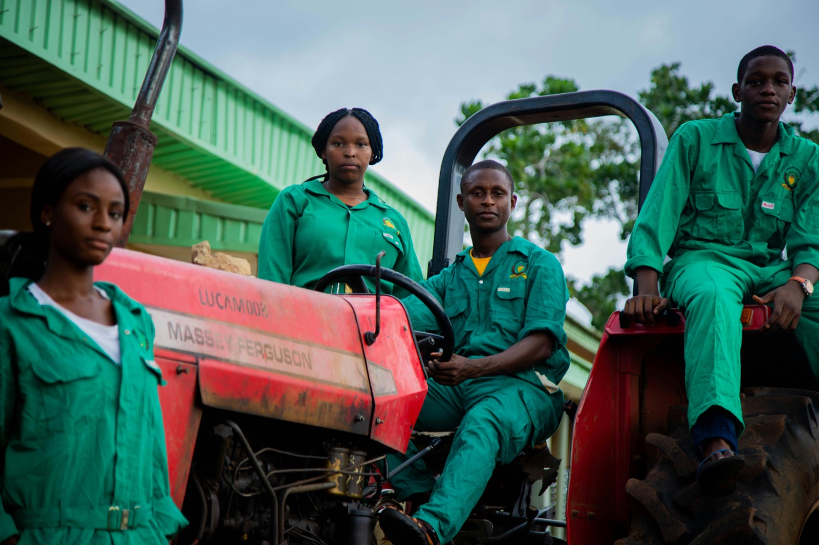 A farm crew in green work clothes on a tractor