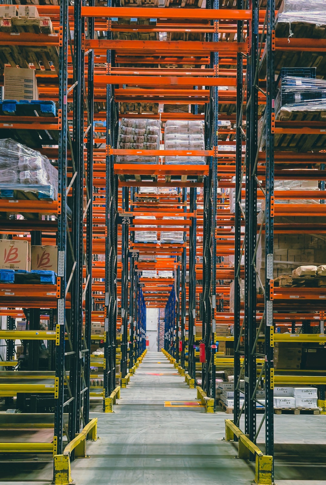 A long corridor of warehouse racks, black and white
